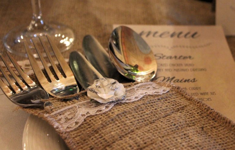 Posate e menù stampato sulla tavola di una cena con delitto